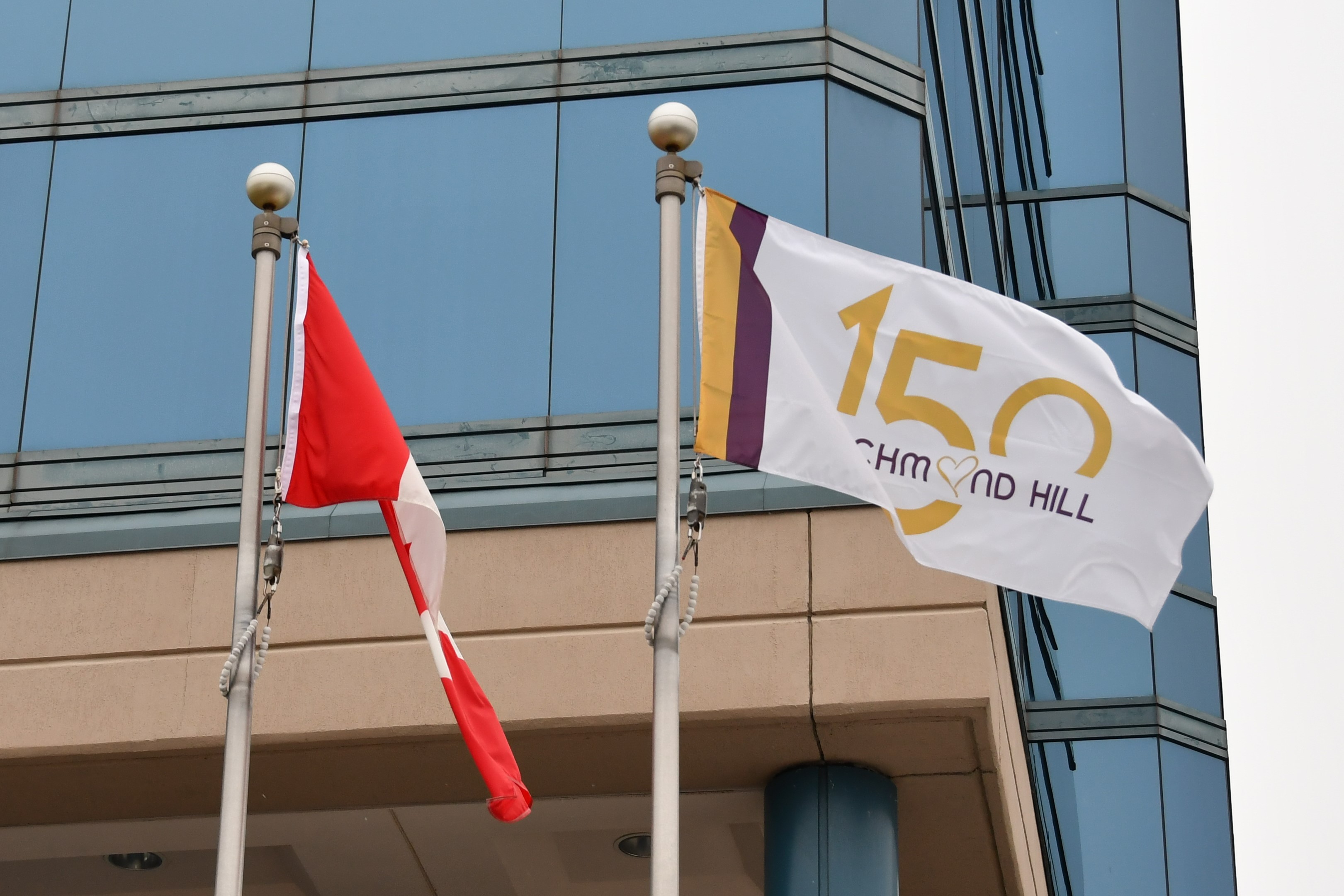 New Richmond Hill 150 flag flying beside Canadian Flag